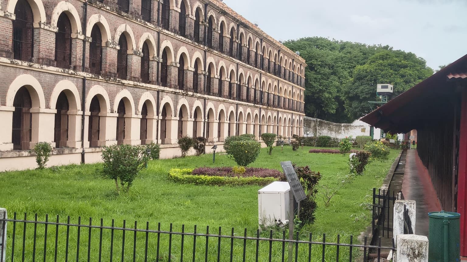 The arched cell wings of Cellular Jail seen across the memorial gardens, Port Blair