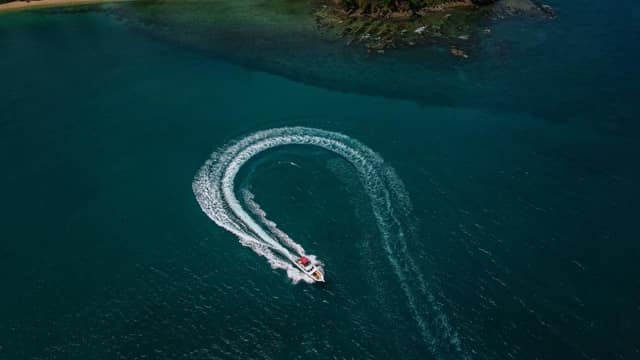 Aerial view of a speedboat carving a loop off the Elephant Beach reef