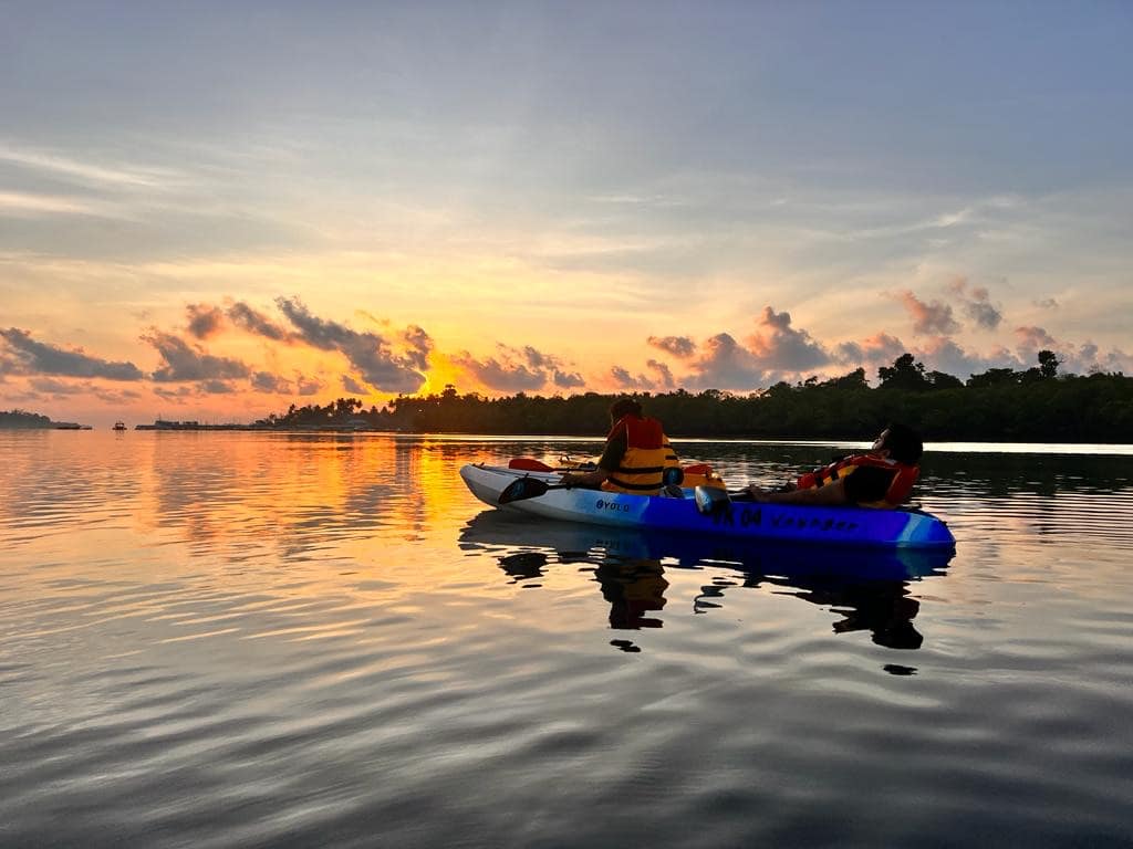 A kayak on glass-clear water over a live coral reef at Havelock