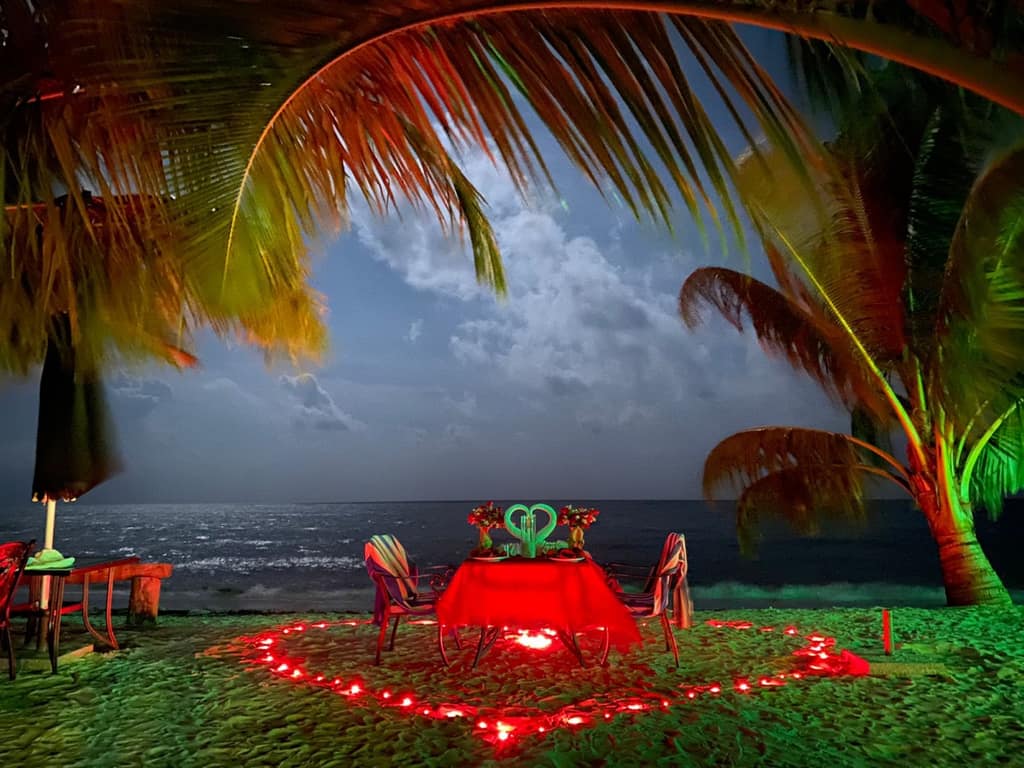 Candlelight dinner laid out on the sand at dusk on a beach in the Andamans