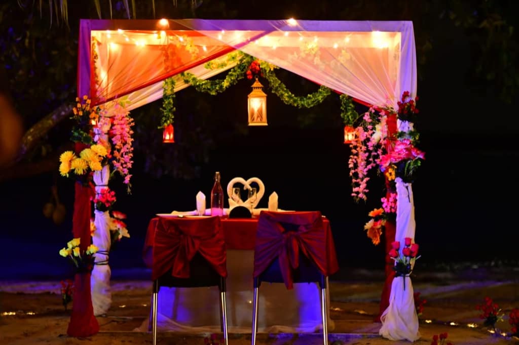 A candlelight dinner set up on the beach at dusk in the Andamans