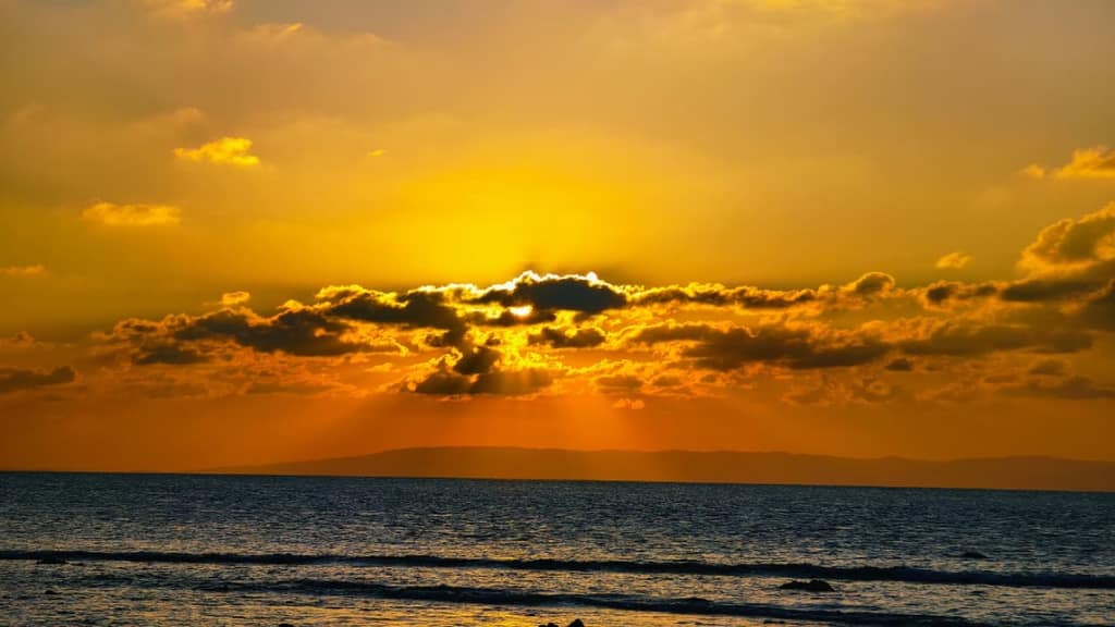 Dramatic sunset breaking through clouds at Laxmanpur Beach, Neil Island