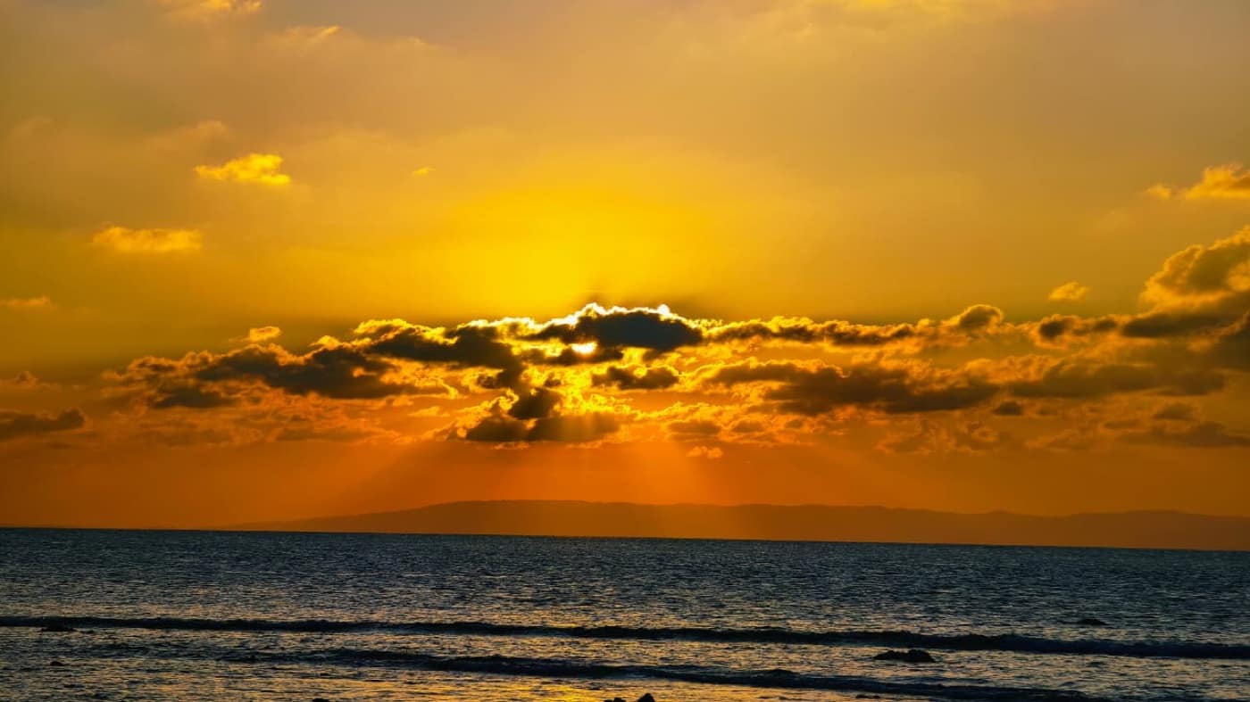 Sun breaking through cloud at sunset over Laxmanpur Beach, Neil Island