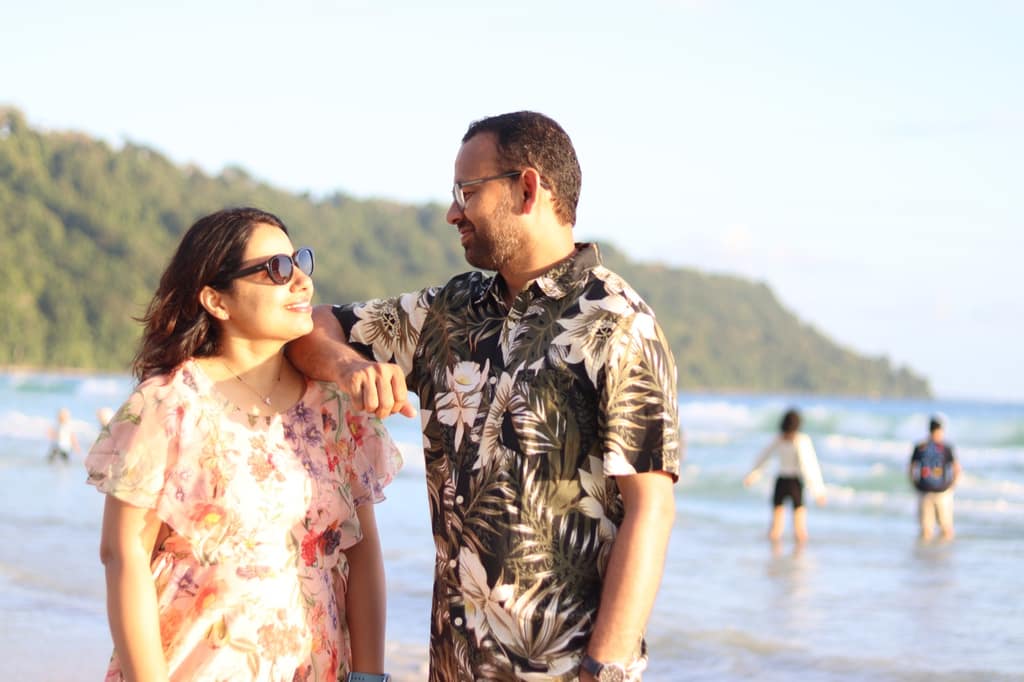 A couple at golden hour on an Andaman beach, hills behind them